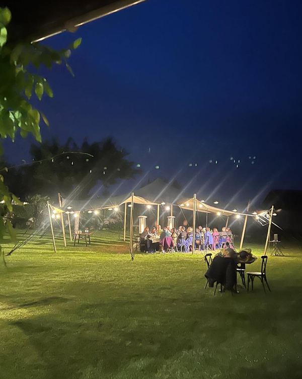 Dîner sous les guirlandes lumineuses, le soir au jardin